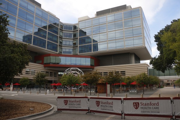 Image of a building part of Stanford Hospitals with banners reading Stanford Healthcare surrounding the building