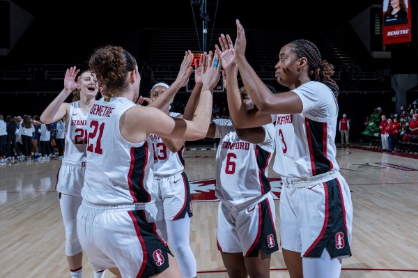Women's basketball players in huddle.