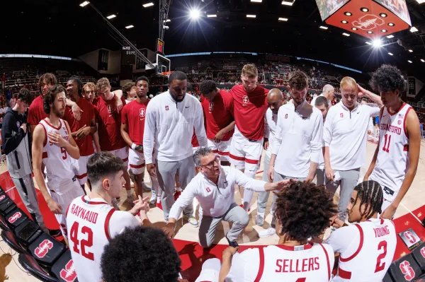 Basketball team huddled around coach.